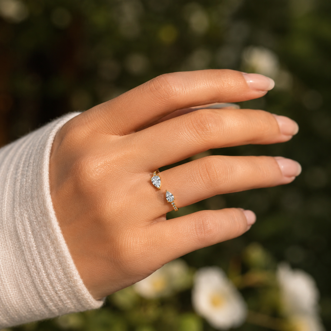 18K gold pear shape diamond luxury ring on hand outdoor lifestyle view