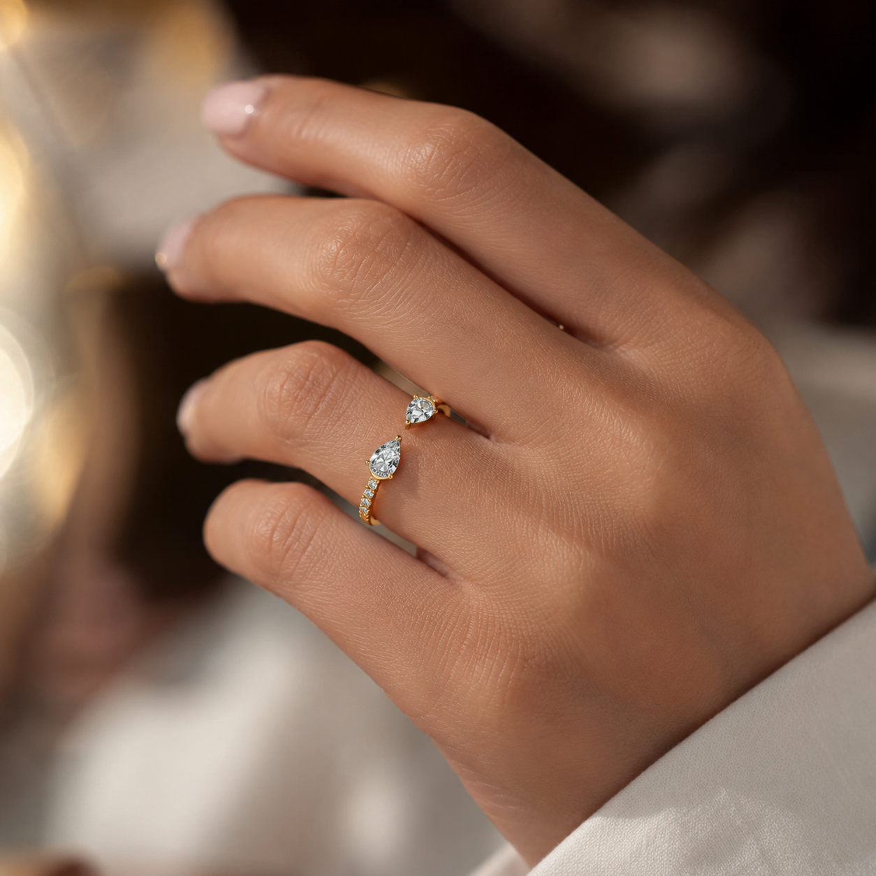 Woman wearing 18K gold pear shape diamond ring with VVS clarity