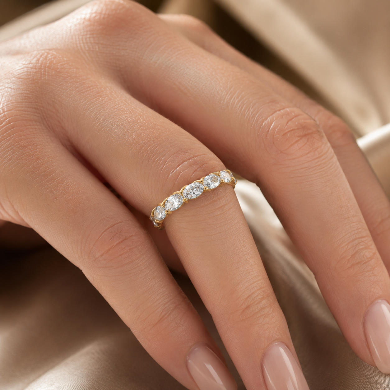 Woman wearing 18K gold oval diamond full eternity ring with VVS clarity